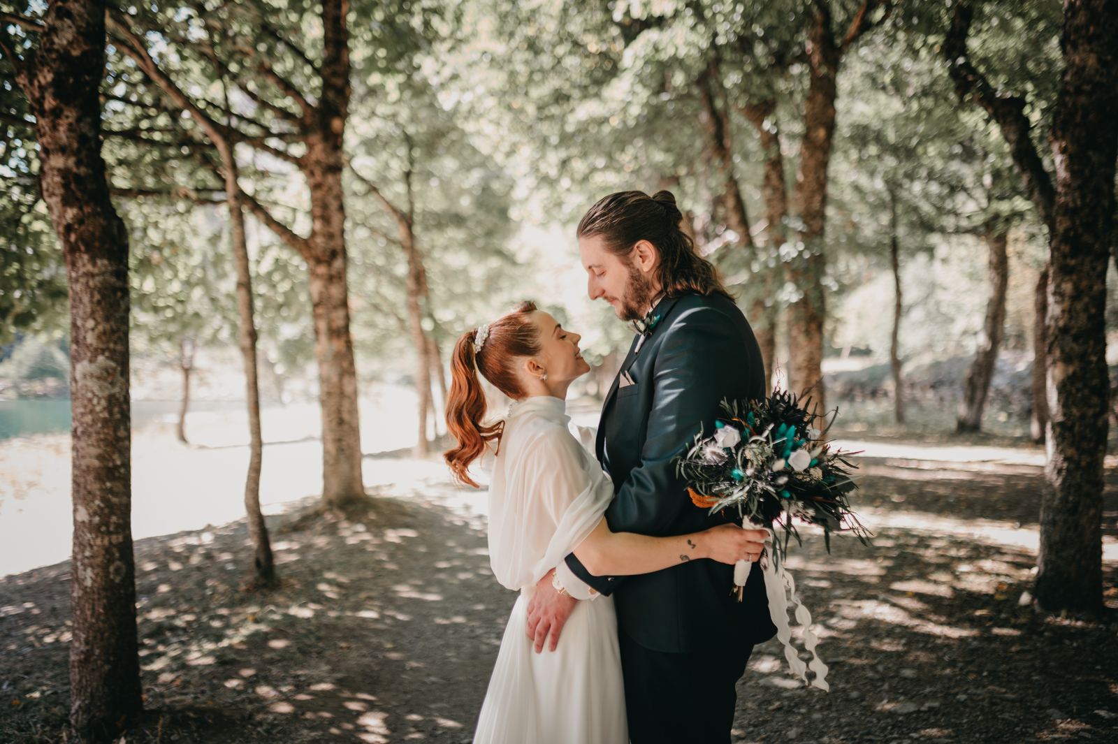 Novios abrazados entre los árboles de un bosque del Pirineo