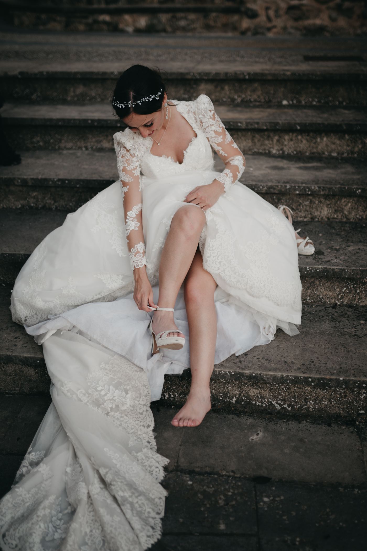 La novia poniéndose los zapatos en una escalinata